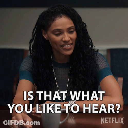 A Woman Sitting At A Table With The Words " Is That What You Like To Hear " Written Above Her GIF