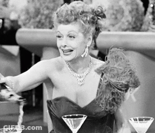 A Woman Sitting At A Table With Three Martini Glasses In Front Of Her GIF