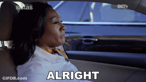 A Woman Sitting In A Car With The Word Alright On The Bottom GIF