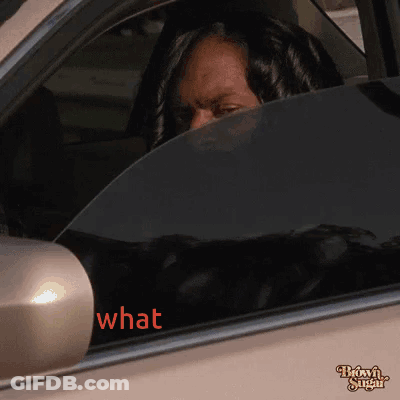 A Woman Sitting In A Car With The Word What Written On The Window GIF