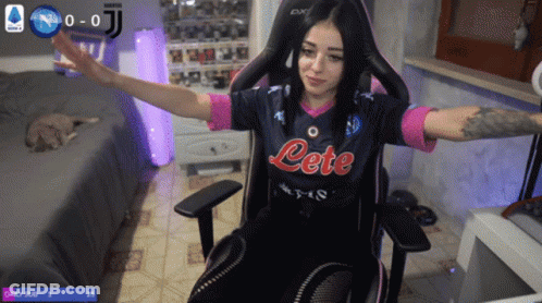 A Woman Sitting In A Chair Wearing A Jersey That Says Lete GIF