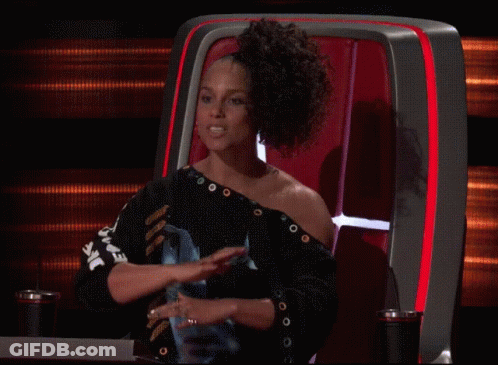 A Woman Sitting In A Chair With A Shirt That Says ' Ear ' On It GIF