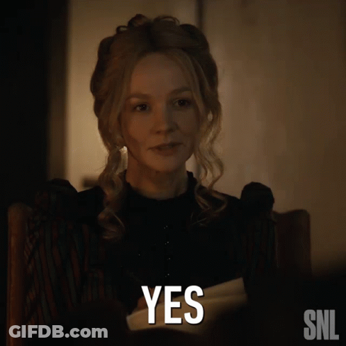 A Woman Sitting In A Chair With A Snl Logo Next To Her GIF