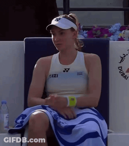 A Woman Sitting In A Chair With A Towel Around Her Waist That Says Dubai On It GIF