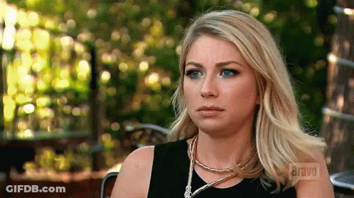 A Woman Sitting In A Chair With Bravo On The Screen GIF