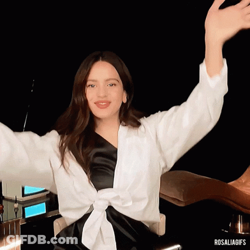A Woman Sitting In A Chair With Her Arms Outstretched And The Hashtag Rosaliagifs GIF