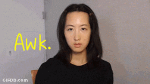 A Woman Sitting In A Chair With The Word Awk Written In Yellow GIF