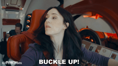 A Woman Sitting In A Chair With The Words Buckle Up Above Her GIF