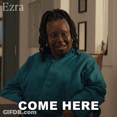 A Woman Sitting In A Chair With The Words Come Here Behind Her GIF