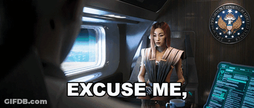 A Woman Sitting In A Chair With The Words Excuse Me On The Bottom Right GIF
