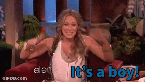 A Woman Sitting In A Chair With The Words " It 'S A Boy " On The Bottom GIF