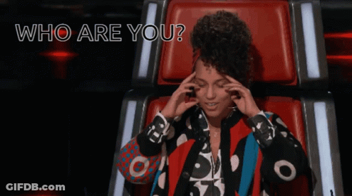 A Woman Sitting In A Chair With The Words " Who Are You " Written Above Her GIF