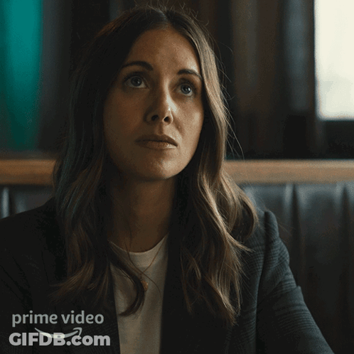A Woman Sitting In A Diner With The Word Oof Written On The Bottom GIF