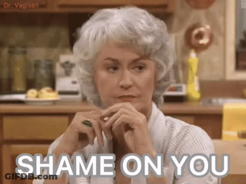 A Woman Sitting In A Kitchen With The Words " Shame On You " Written On Her Face GIF