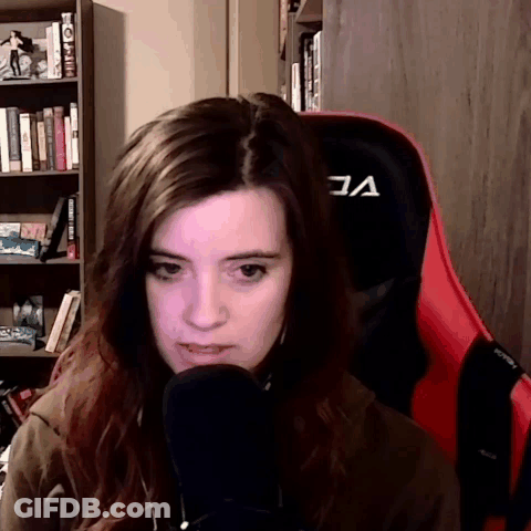 A Woman Sitting In A Red Chair With The Letter A On The Back GIF