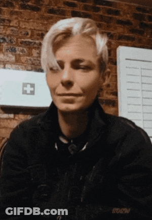 A Woman Sitting In Front Of A Brick Wall With A First Aid Kit In The Background GIF