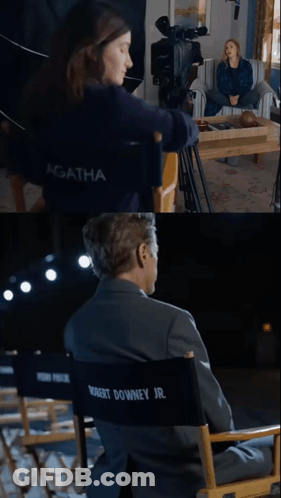 A Woman Sitting In Front Of A Camera And A Man In A Director 'S Chair GIF