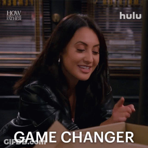 A Woman Sitting In Front Of A Cardboard Box With The Words Game Changer On Her Face GIF