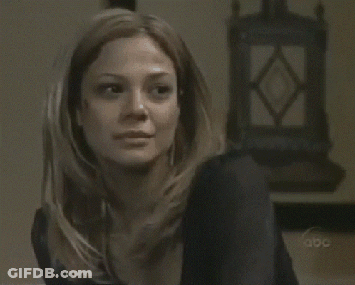 A Woman Sitting In Front Of A Clock That Says Abc GIF