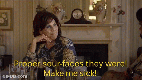 A Woman Sitting In Front Of A Fireplace With The Words Proper Sour Faces They Were Make Me Sick GIF