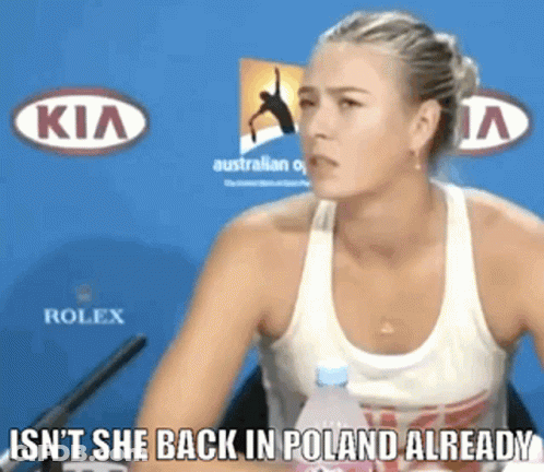 A Woman Sitting In Front Of A Kia And Rolex Banner GIF