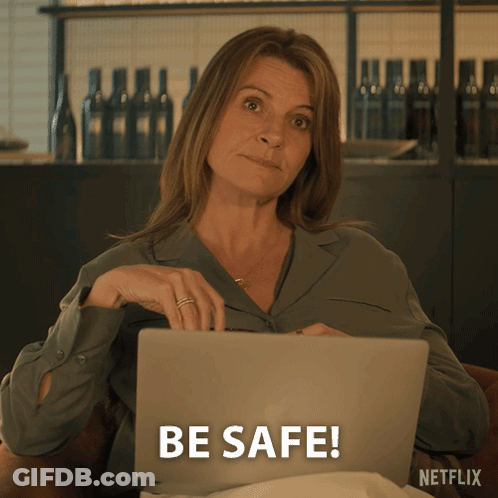 A Woman Sitting In Front Of A Laptop That Says Be Safe On The Screen GIF
