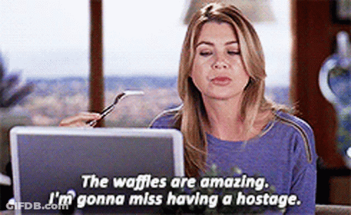 A Woman Sitting In Front Of A Laptop With A Fork In Her Hand And The Words " The Waffles Are Amazing " GIF