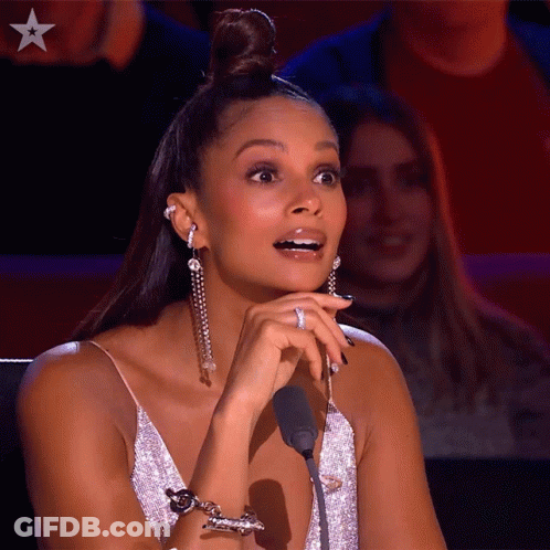 A Woman Sitting In Front Of A Microphone With A Star On The Bottom Left GIF