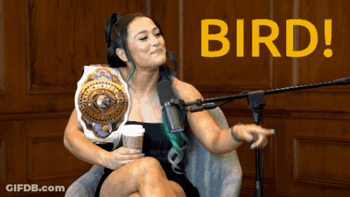 A Woman Sitting In Front Of A Microphone With The Word Bird On The Bottom Right GIF