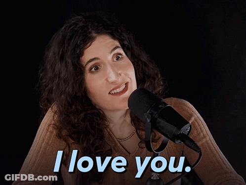 A Woman Sitting In Front Of A Microphone With The Words I Love You Above Her GIF