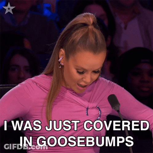 A Woman Sitting In Front Of A Microphone With The Words " I Was Just Covered In Goosebumps " GIF