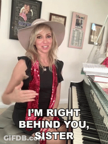 A Woman Sitting In Front Of A Piano With The Words I 'M Right Behind You Sister GIF