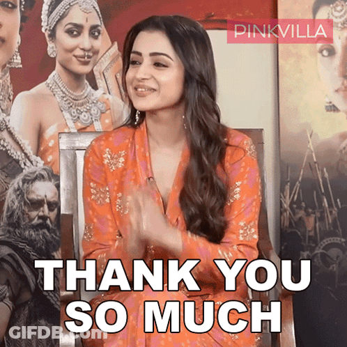 A Woman Sitting In Front Of A Poster That Says Pinkvilla GIF