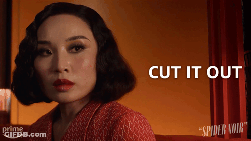 A Woman Sitting In Front Of A Red Curtain With The Words Cut It Out Above Her GIF