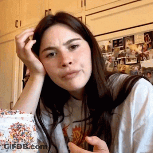 A Woman Sitting In Front Of A Refrigerator With A Picture Of A Man On It That Says ' A ' On It GIF
