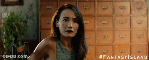 A Woman Sitting In Front Of A Row Of Drawers With The Hashtag Fantasy Island GIF