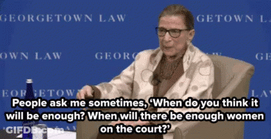 A Woman Sitting In Front Of A Sign That Says ' Georgetown Law ' On It GIF