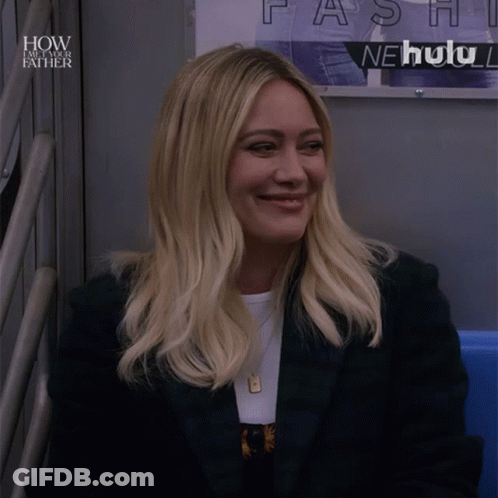 A Woman Sitting In Front Of A Sign That Says How I Met Your Father GIF