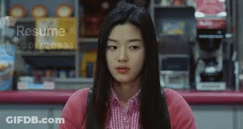 A Woman Sitting In Front Of A Sign That Says Resume At The Top GIF