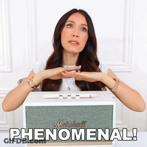 A Woman Sitting In Front Of A White Marshall Speaker GIF