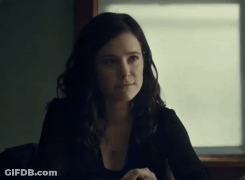 A Woman Sitting In Front Of A Window With A Necklace Around Her Neck GIF