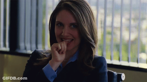 A Woman Sitting In Front Of A Window With Her Hand On Her Mouth GIF
