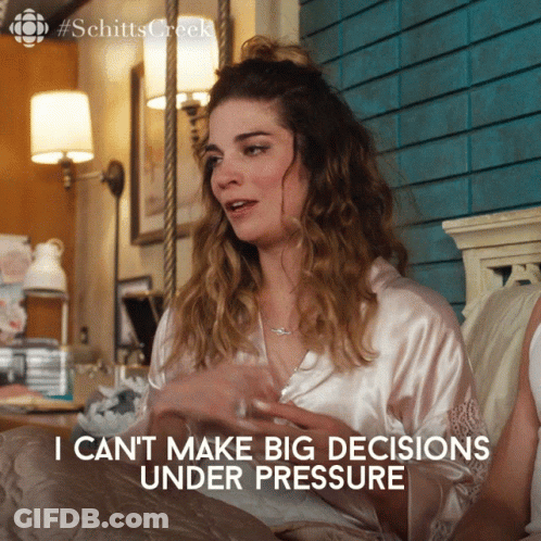 A Woman Sitting On A Bed With The Words I Can T Make Big Decisions Under Pressure GIF