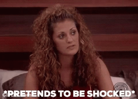 A Woman Sitting On A Bed With The Words Pretends To Be Shocked GIF