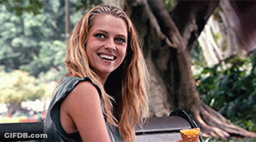 A Woman Sitting On A Bench Holding An Ice Cream Cone GIF