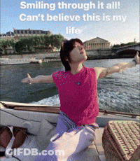 A Woman Sitting On A Boat With Her Arms Outstretched With The Caption Smiling Through It All Can 'T Believe This Is My L GIF