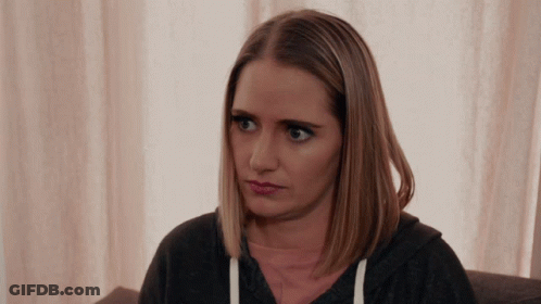 A Woman Sitting On A Couch Looking At The Camera GIF