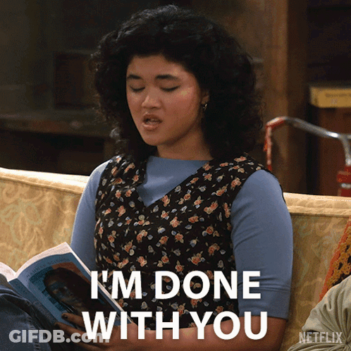 A Woman Sitting On A Couch Reading A Book With The Words I 'M Done With You Below Her GIF