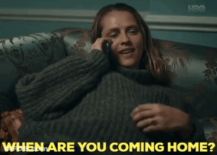 A Woman Sitting On A Couch Talking On A Cell Phone With The Words " When Are You Coming Home " Written In Yellow GIF