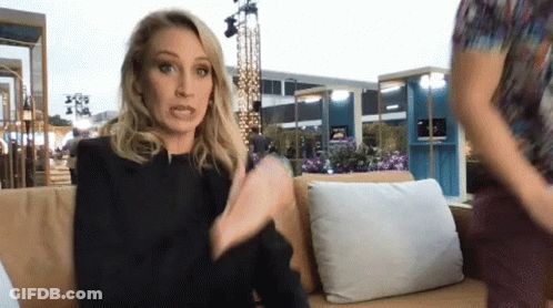 A Woman Sitting On A Couch Talking To Another Person GIF
